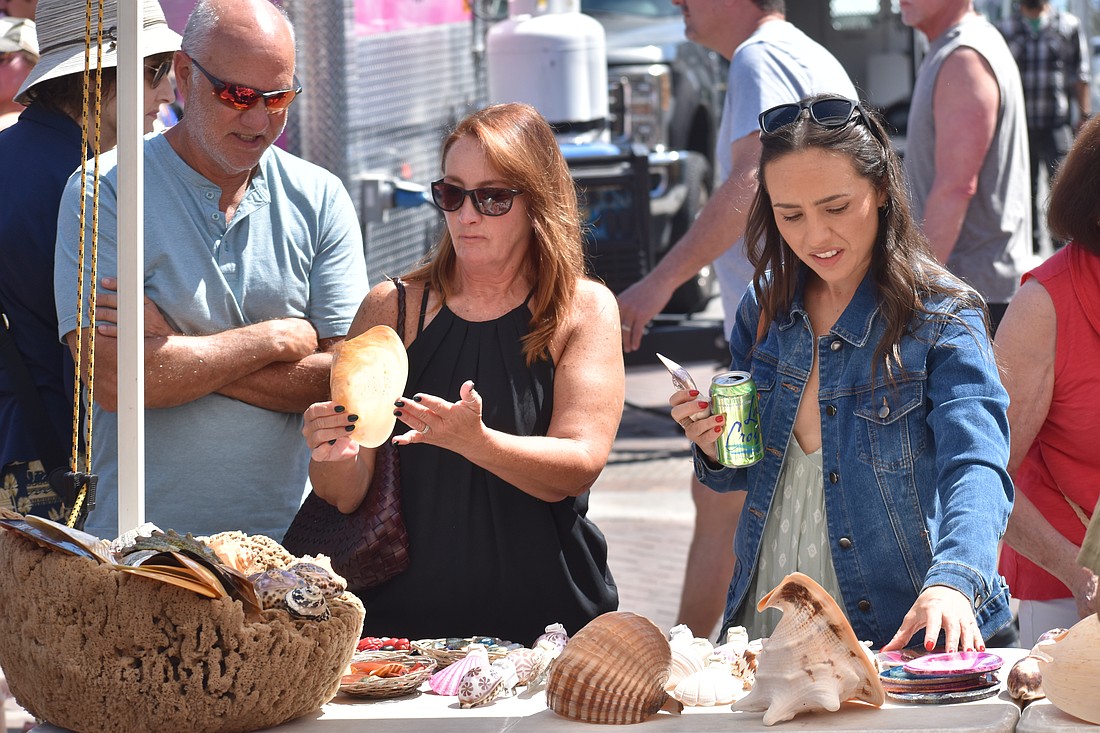 Glenn and Linda Courtney and their daughter Chelsea Courtney look at seashells.