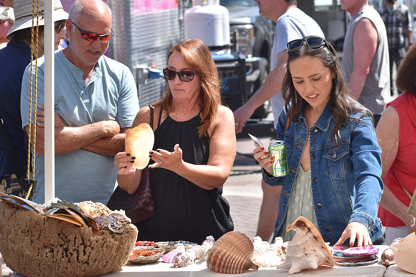 Glenn and Linda Courtney and their daughter Chelsea Courtney look at seashells.