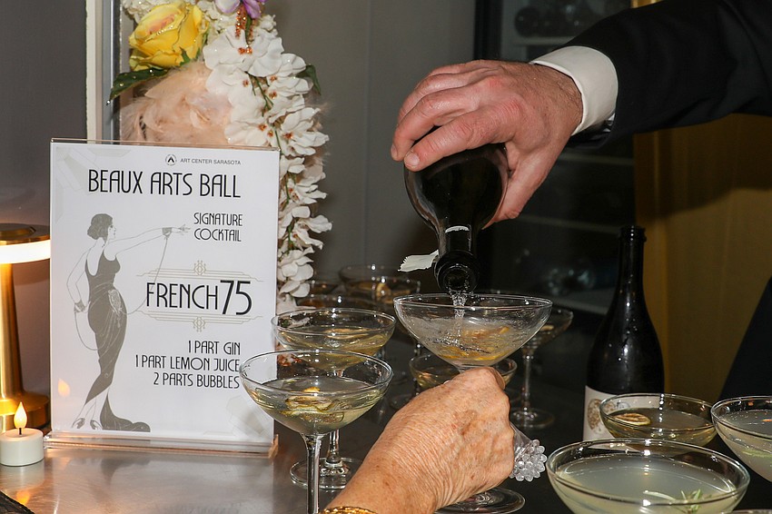 A bartender serves up the signature drink of the evening: a French 75.