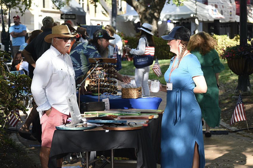 Bill Dodge, who is at the table Marilyn's Creations for his wife Marilyn Dodge, talks to his daughter Melanie Dodge.