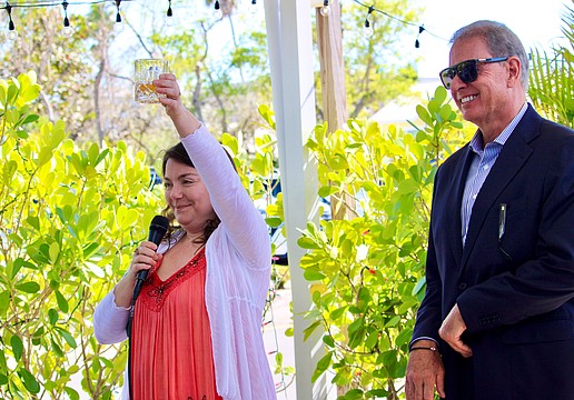 Wearing her mother's favorite color, Abby Ferreira, one of Cathy Ann "Cam" Maddox's children, raises a glass in memory of her mother on March 21 at Harry's Continental Kitchens with Brian Maddox. He said his late wife wanted a celebration of life that brought together loved ones and friends to smile, share fond memories and show their support for the Longboat Key Turtle Watch, a conservation program she passionately championed.
