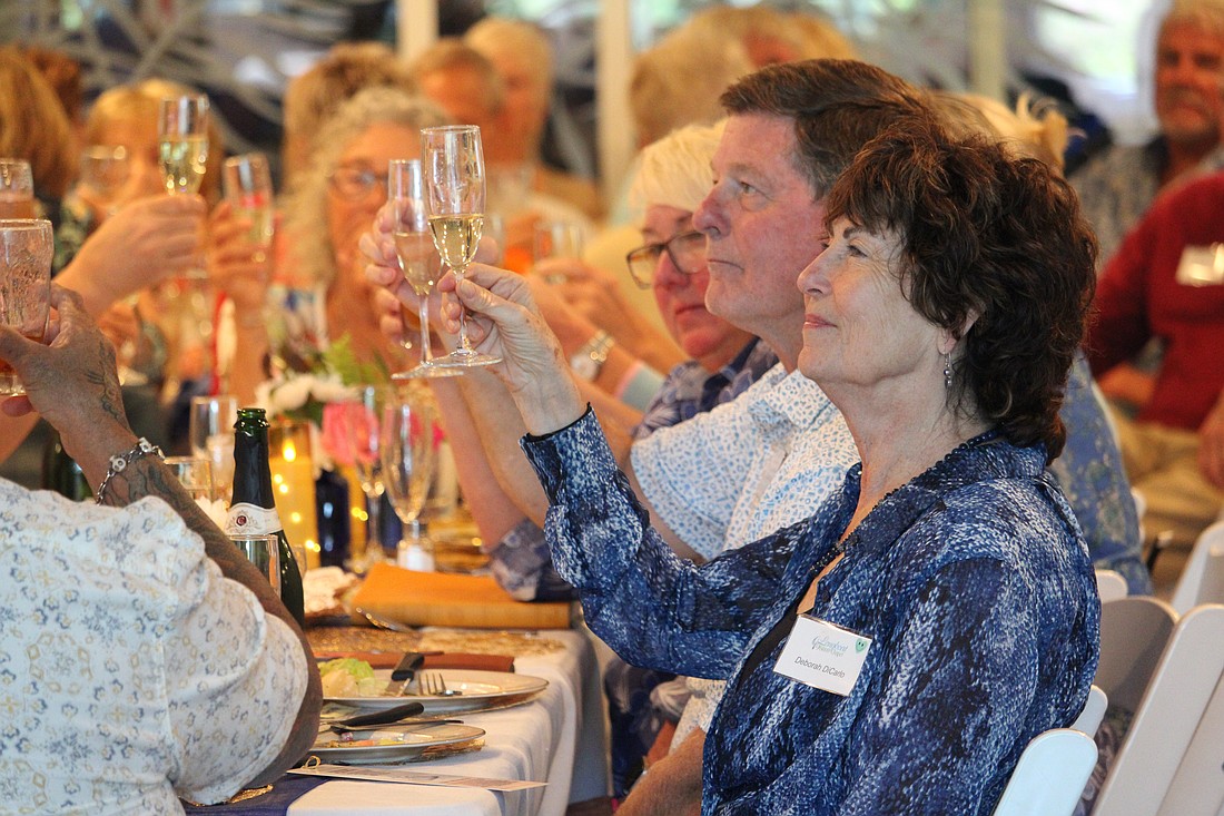 Deborah DiCarlo and approximately 150 fellow celebrants raise a glass to toast Longboat Island Chapel's 70th anniversary. Attendees shared memories and cake at the festivities March 22 at Shook Hall.