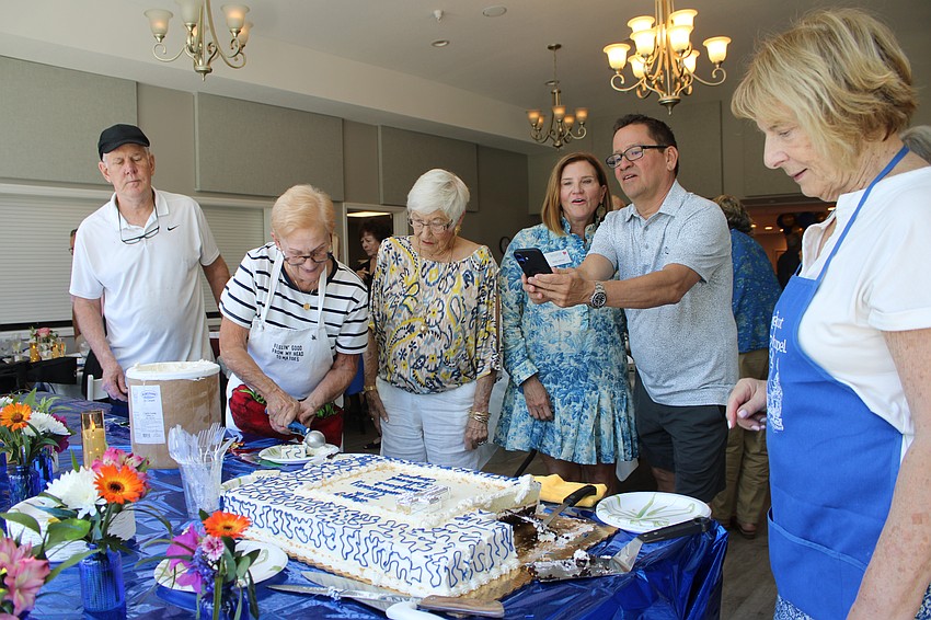 The Longboat Island Chapel kitchen team starts divying up celebratory cake while congregation members sing 