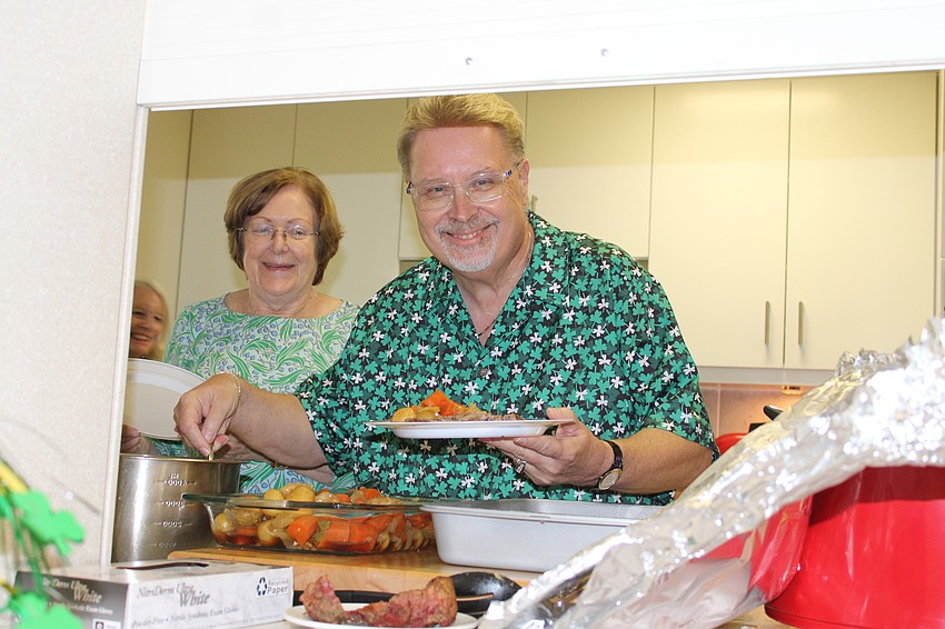 David Stasney dishes up corned beef and cabbage for the traditional Irish dinner congregation members at All Angels by the Sea Episcopal Church prepared.