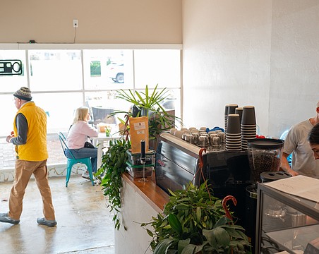 Co-owner Chris Carter works with a barista behind the counter of the second location of Sips, which opened at 3172 Gulf of Mexico Drive this month.