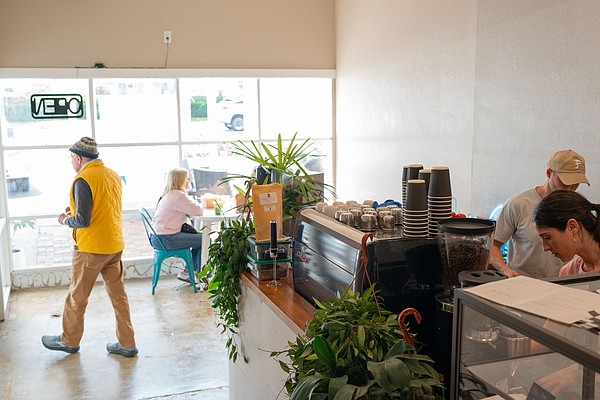 Co-owner Chris Carter works with a barista behind the counter of the second location of Sips, which opened at 3172 Gulf of Mexico Drive this month.