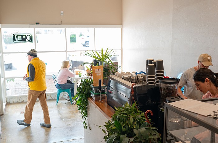 Co-owner Chris Carter works with a barista behind the counter of the second location of Sips, which opened at 3172 Gulf of Mexico Drive this month.