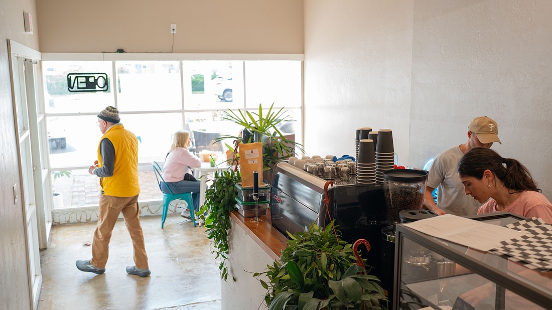 Co-owner Chris Carter works with a barista behind the counter of the second location of Sips, which opened at 3172 Gulf of Mexico Drive this month.