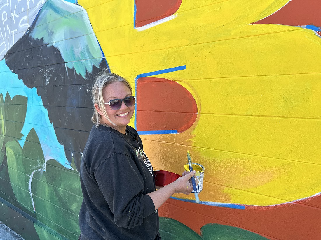 Artist Brook Page works on the Highwaymen-themed mural