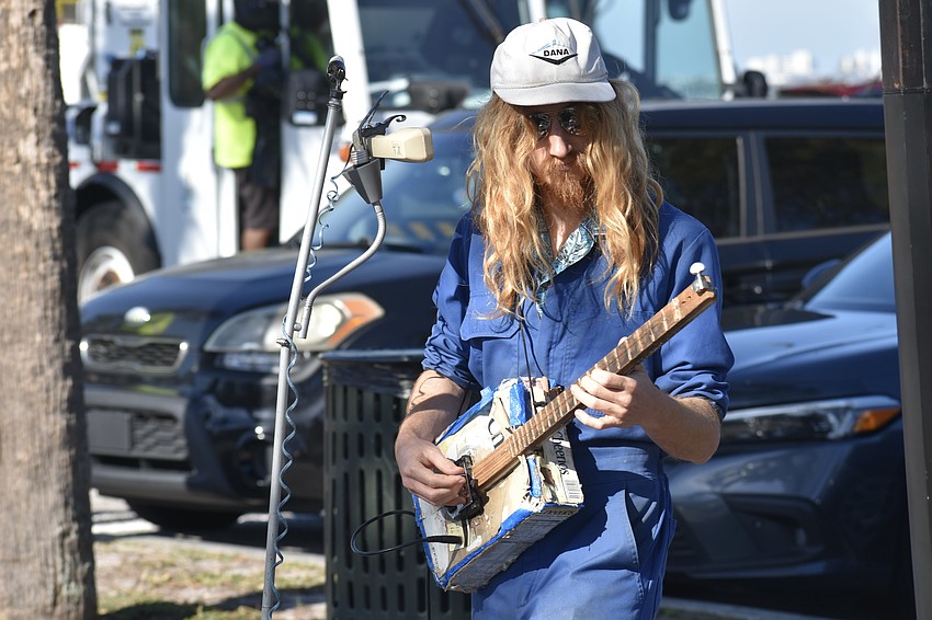 Jack Berry of The Garbage-Men band, which provided live music at the event, plays on a guitar created from a cereal box as the recycling gets underway.