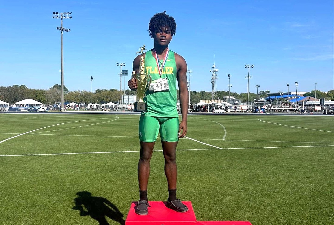 FPC's La'Darius Simmons holds up trophy on the podium after winning the javelin title at the Bob Hayes Invitational. Simmons has won the event in each of the past four meets. Courtesy photo