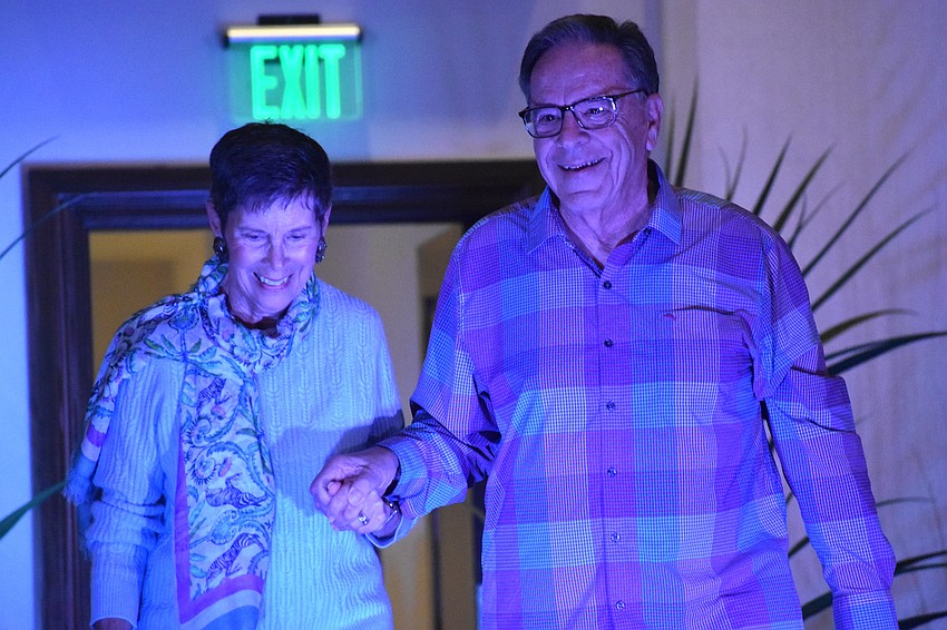 Vicki DiPaolo models a sweater and scarf from J. McLaughlin alongside her husband Bill DiPaolo at the 