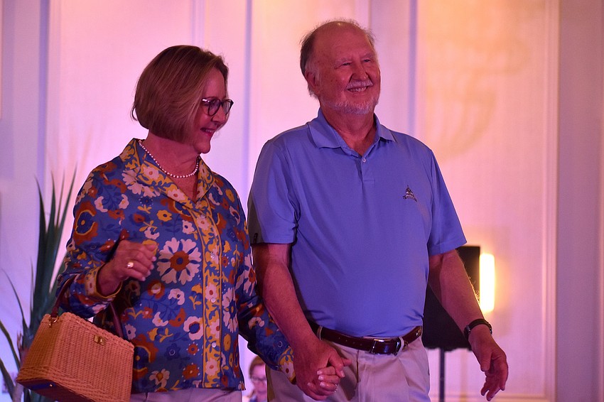 Cynde Mutryn, in a look by J. McLaughlin, and Bill Mutryn walk the runway at the 