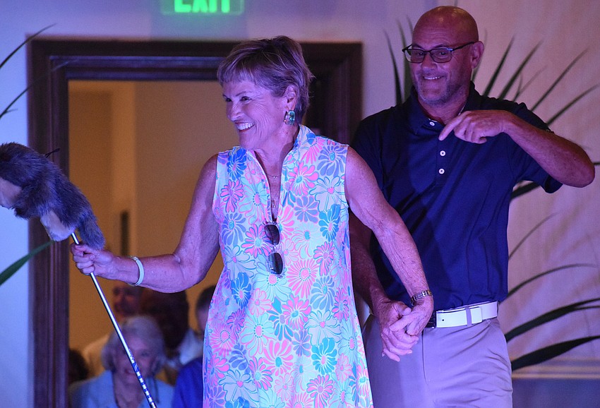 Susie Melum, in a golf outfit by Darci's boutique, walks the runway with Ashley Hayden at the 