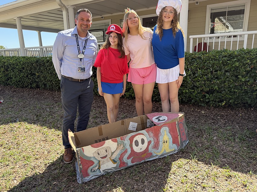Head of School Alex Birchenall talked to eighth-graders Ashley Hardoon, Abigail Turowicz and Jemma Blunk about their handcrafted boat before the boat races, which is a tradition at the school. Birchenall said engaging with students is crucial to understanding their passions and supporting their success.