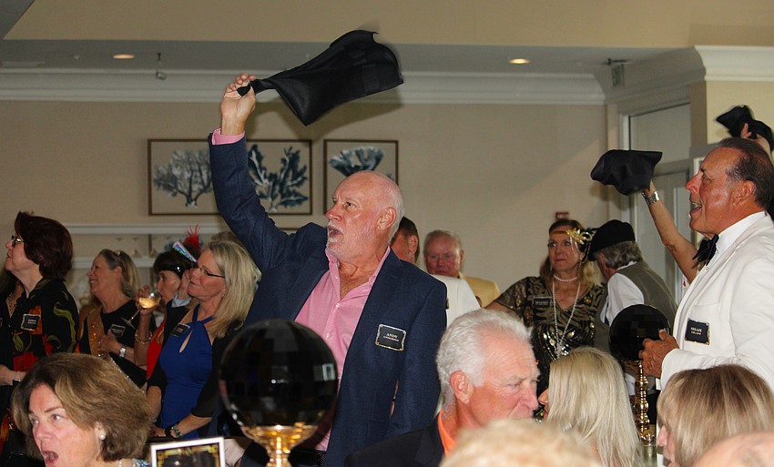 Andy Anderson and fellow attendees at the Friars Club annual dinner swing their towels and glow sticks while singing the Queen song spoof, 