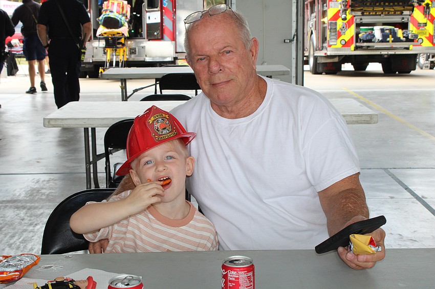 John Gubernat III and John Gubernat Sr. enjoy some snacks at the Longboat Key Fire Rescue open house after checking out the big rigs.