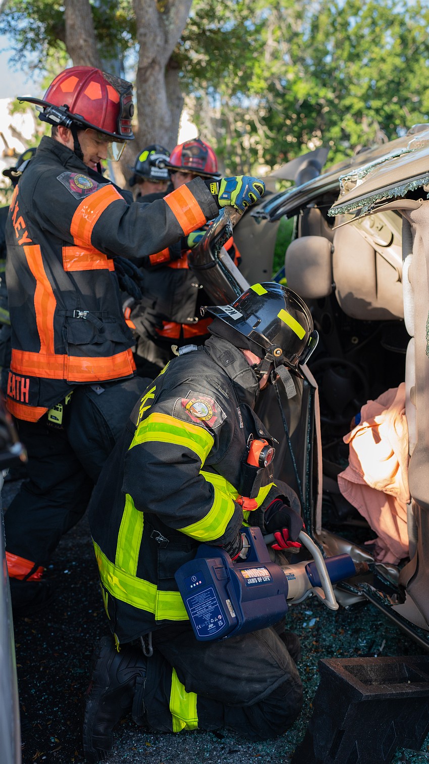 Longboat Key Firefighter Paramedic Tyler Brunton cuts a support beam as Lt. Daniel Heath pulls the roof back from an overturned vehicle during an extrication training session at Longboat Key Fire Station 91 Thursday, March 26.