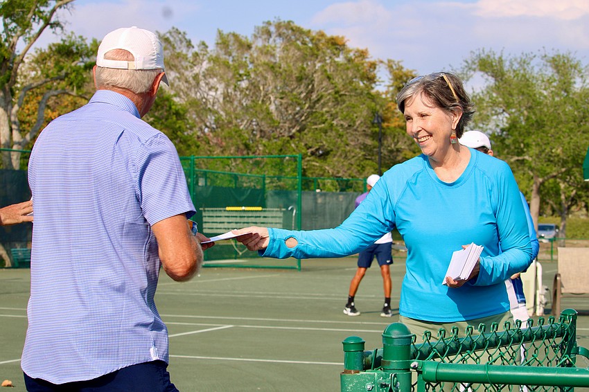 Grace Hackett helps pass out thank-you gifts to team captains and organizers of this season's tennis matches.