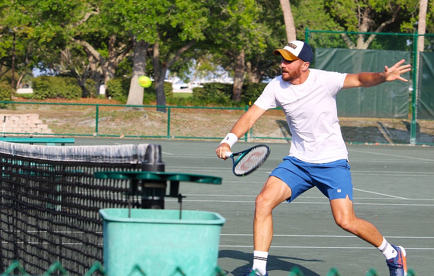 David Pfister gets under the tennis ball to return it.