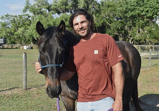 Nate Gold stands with his horse Alonzo.