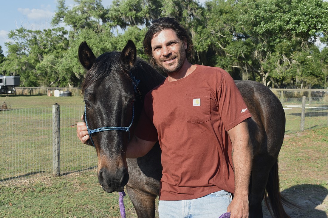 Nate Gold stands with his horse Alonzo.