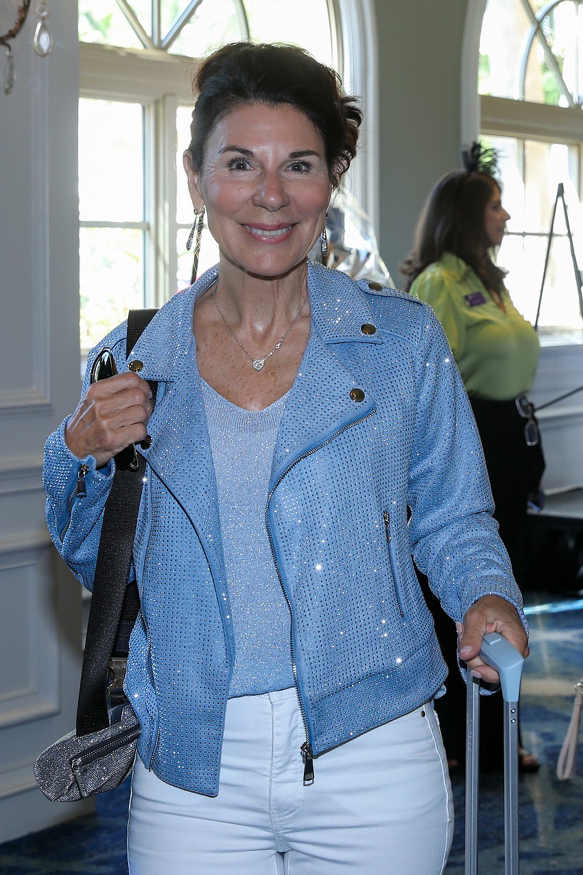 Model Bambi Forristall wheels her suitcase into the dressing area.