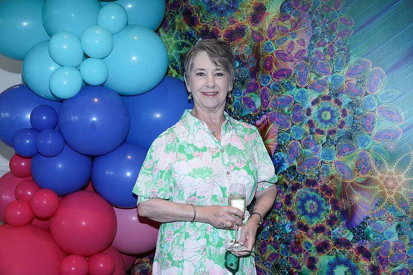 Susan Mann stops by for a photo on the colorful kaleidoscope of a backdrop.