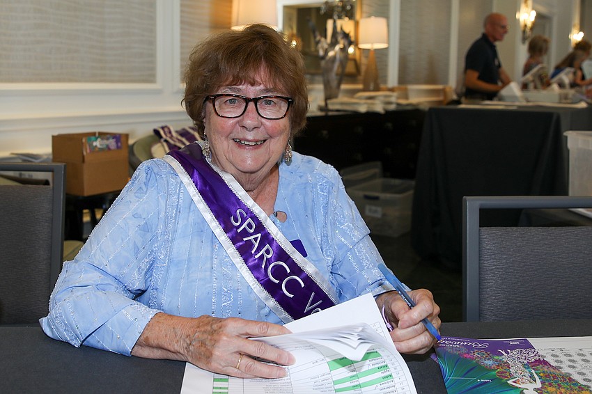 Volunteer Judy Wolff registers some of the 650 guests.