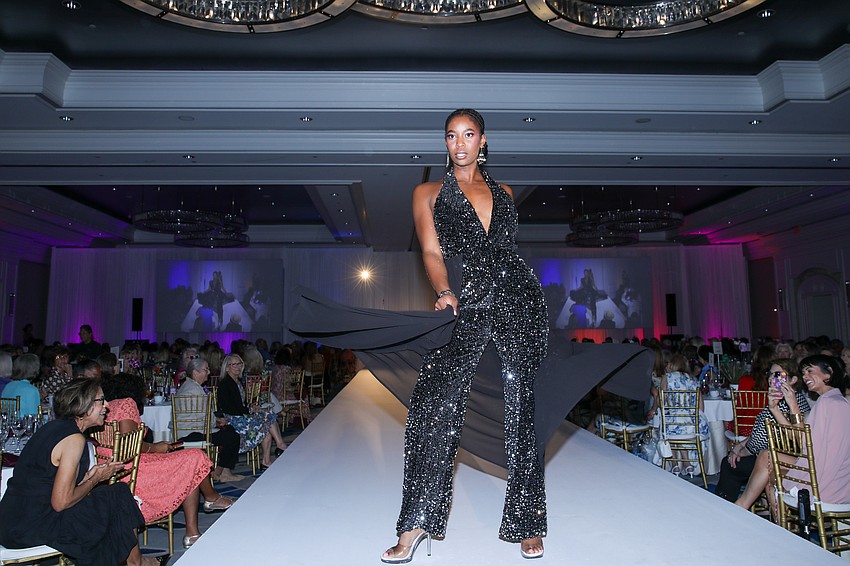 Faith Adesanya in a black sequined jumpsuit with a skirt.