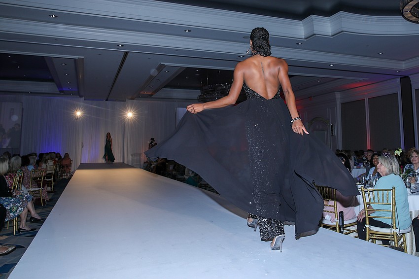 Faith Adesanya flies down the runway in this backless eveningwear.