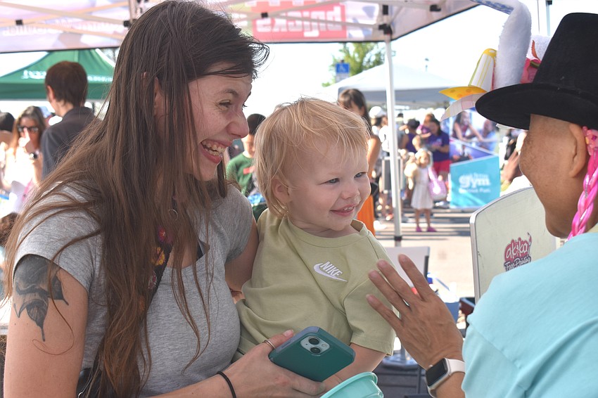 Bradenton's Kali Zinaman and her 1-year-old son, Finley Dunn, greet Akiko Campbell of Akiko Graphics who provides face painting for Eggstravaganza.