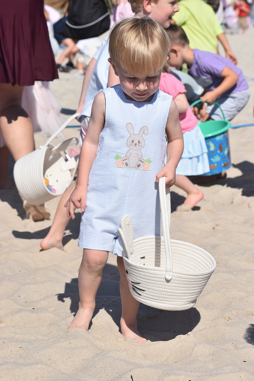 Lakewood Ranch's Forrest Turner, 2, takes his time gathering eggs at Eggstravaganza March 28.
