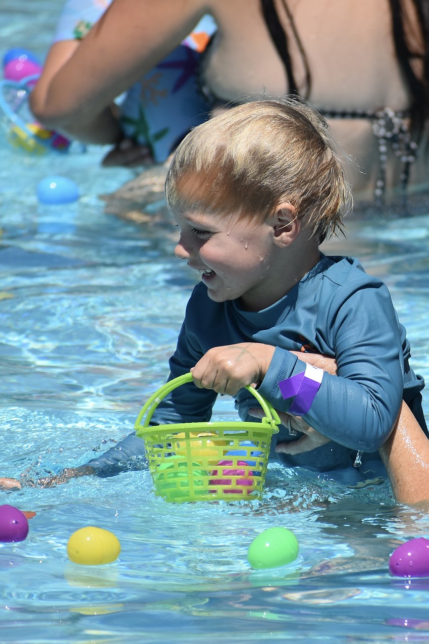 Thomas Herke, 3, collects the eggs around him.