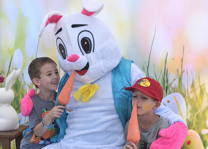 Rosedale's Joaquin Schutzbach, 4, and London Schutzbach, 6, feed carrots to the Easter Bunny during Eggstravaganza March 28.