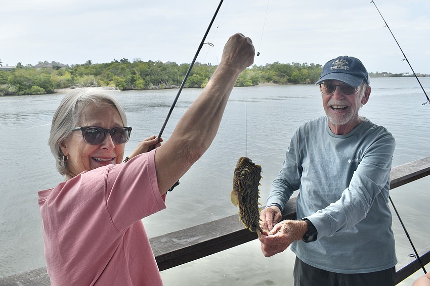 Jaki Becker displays a porcupinefish she caught while fishing with Norman Olshansky, who was among those helping to manage the fishing station.