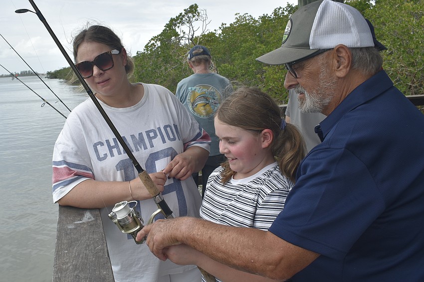 Nadine Haubold, her daughter Jette Haubold, 10, and her father Michael Haubold visit the fishing station. Nadine's parents have an apartment in The Landings, which she says has been a frequent destination from her family's home in Germany for over 20 years. 
