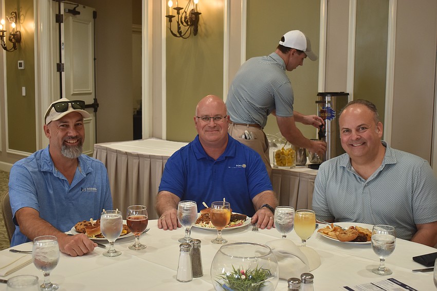 Rotary Club of Lakewood Ranch members Steve Kelle, Rob Thomas and Ryan Brems socialize and eat before golfing in the Ranch Scramble at Lakewood Ranch Golf and Country Club on March 30.