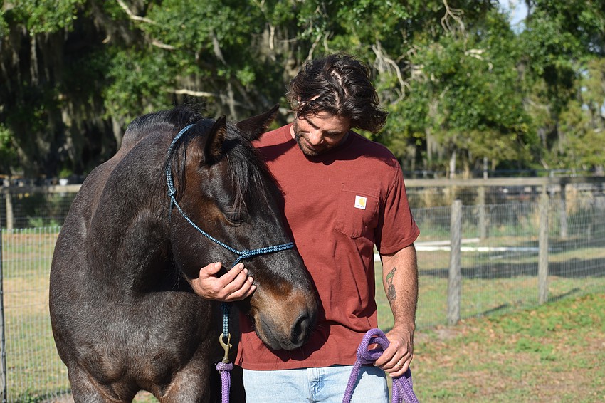 Nate Gold stands with his horse Alonzo.