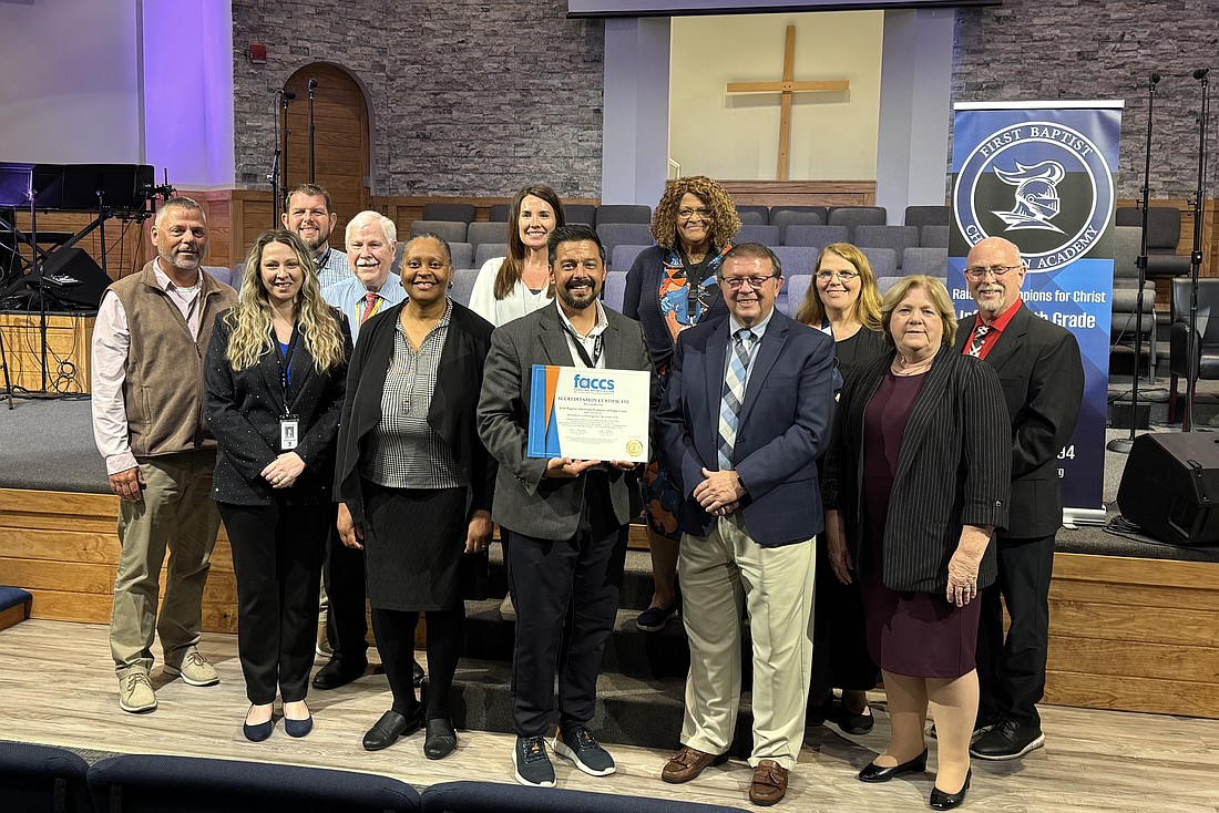 First Baptist Christian Academy Head of School Max Fernandez holds up the Florida Association of Christian Colleges and Schools Accreditation Certificate. Courtesy photo