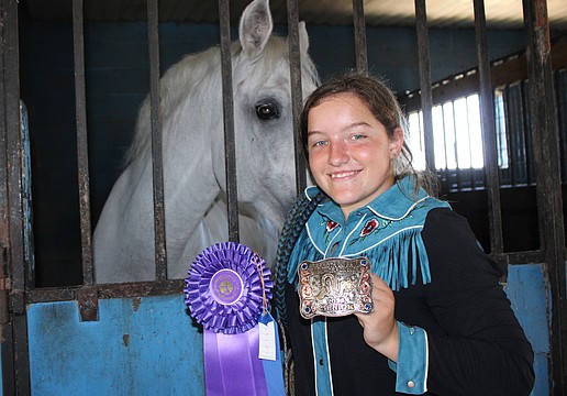 Myakka's Sydney McCullough shows off the first place ribbon and belt buckle she won in January for whip cracking in the senior division at the Manatee County Fair.