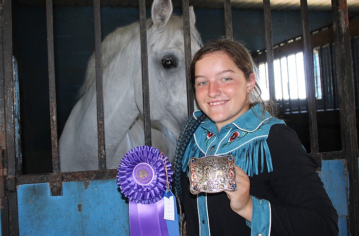 Myakka's Sydney McCullough shows off the first place ribbon and belt buckle she won in January for whip cracking in the senior division at the Manatee County Fair.