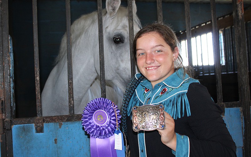 Myakka's Sydney McCullough shows off the first place ribbon and belt buckle she won in January for whip cracking in the senior division at the Manatee County Fair.