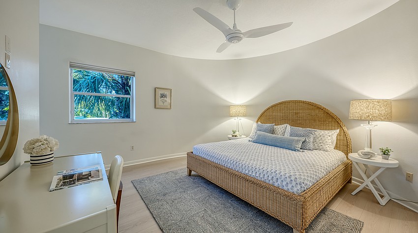 A curved wall and minimal exterior views give the primary bedroom an intimate, secluded air.