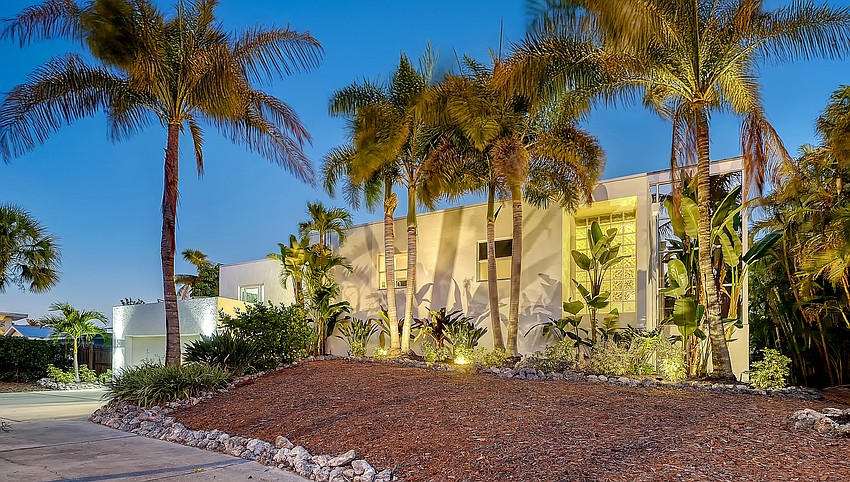 The home’s calm exterior shows its Sarasota School influence, with a simple geometric façade and indigenous landscaping.