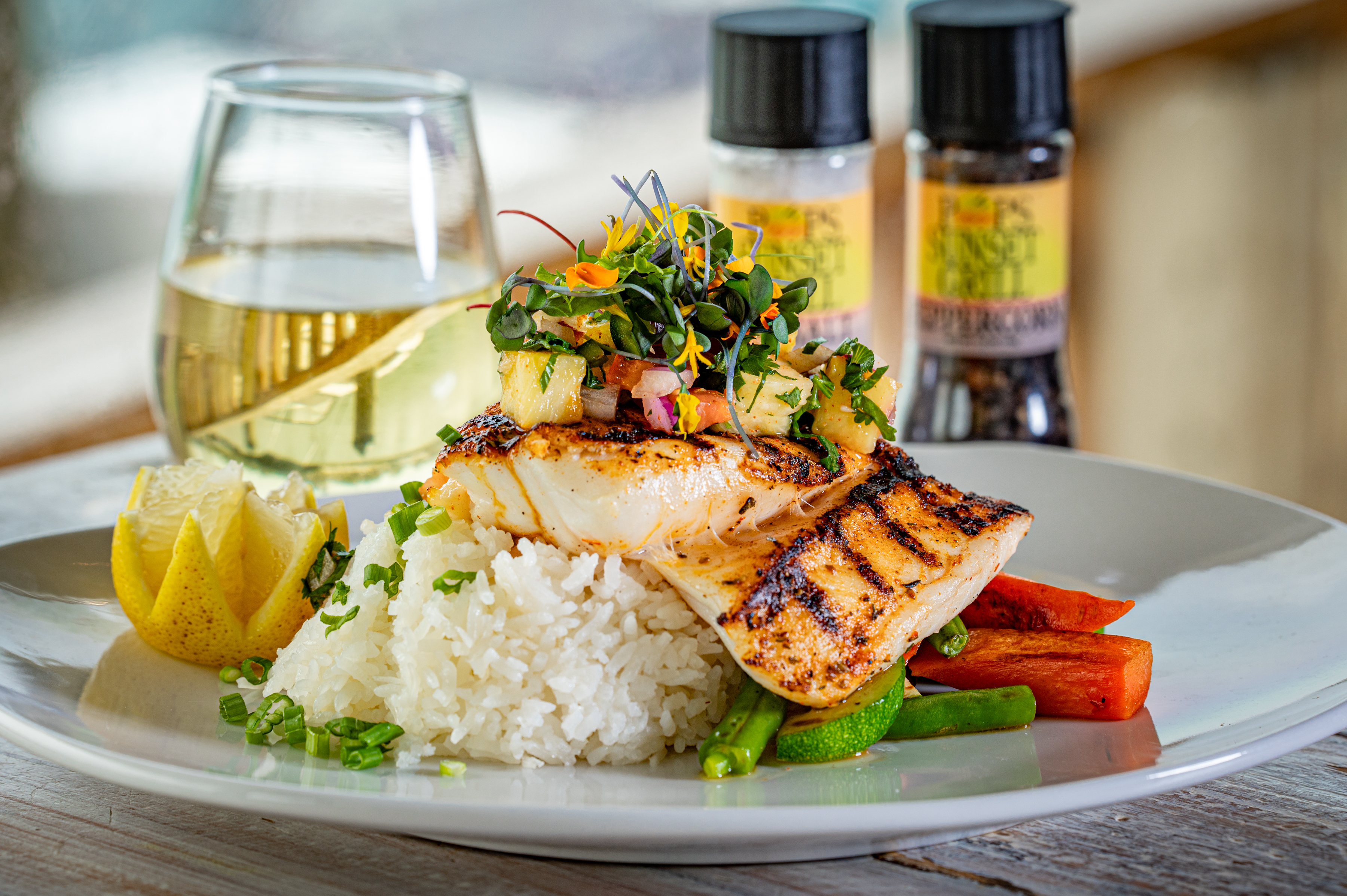 The fresh catch with tropical salsa at Pop’s Sunset Grill pairs locally sourced seafood with pineapple, citrus and herbs, served alongside coconut rice and seasonal vegetables.