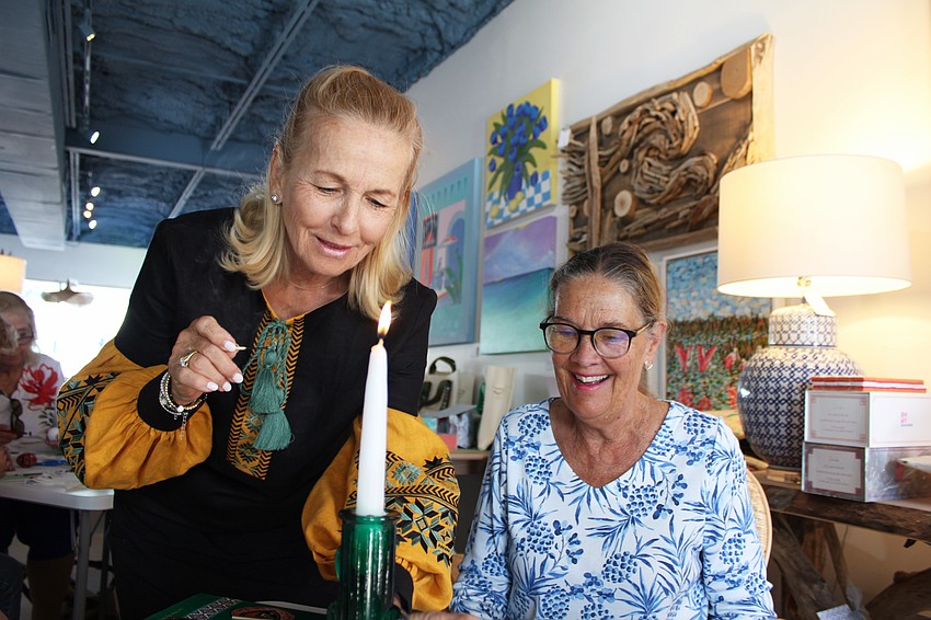 Roksolana Tymiak-Lonchyna and Pam Anderson share a laugh while lighting a candle for pysanky.