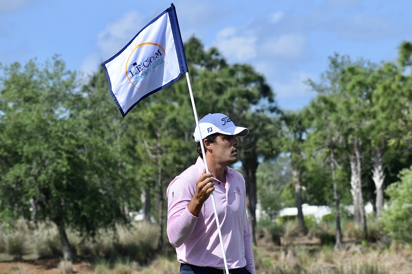 Ricardo Celia removes the flag from the sixth hole before attempting a putt. The 34-year-old Colombian finished three under par and tied for 29th place at the time of stoppage.