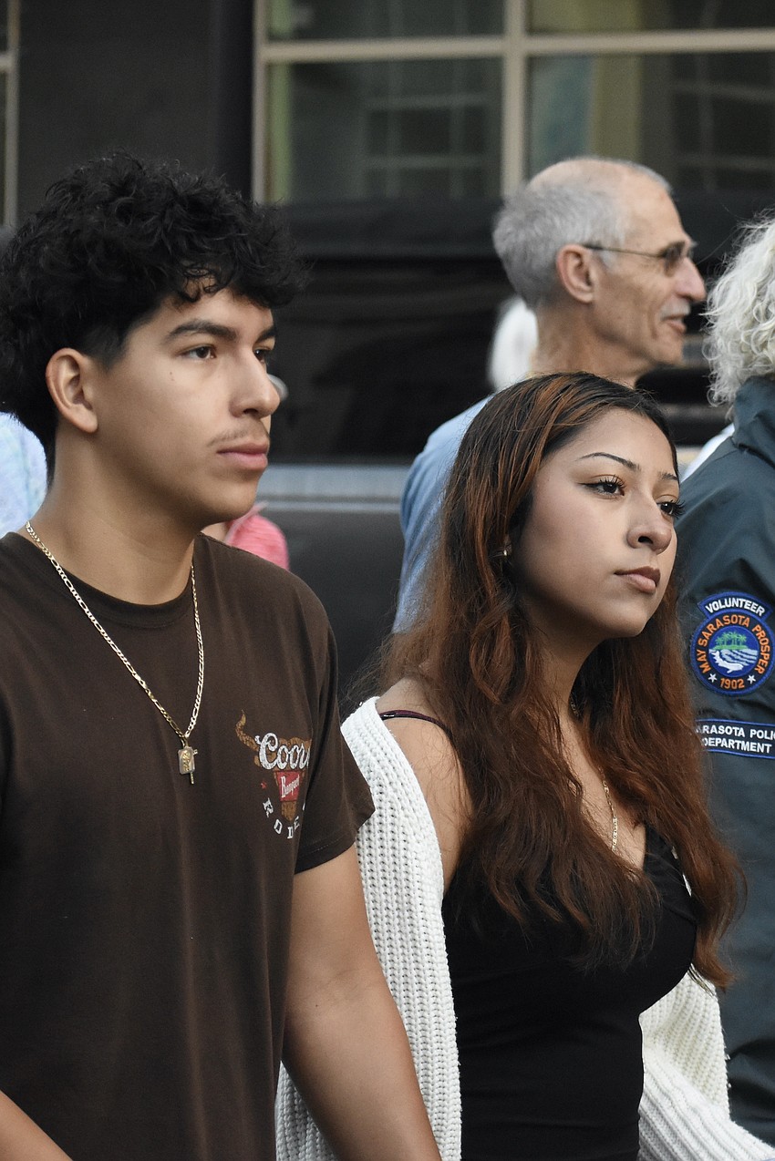 Bryan Picazo and Michelle Roman listen to the ceremony at one of the stations.