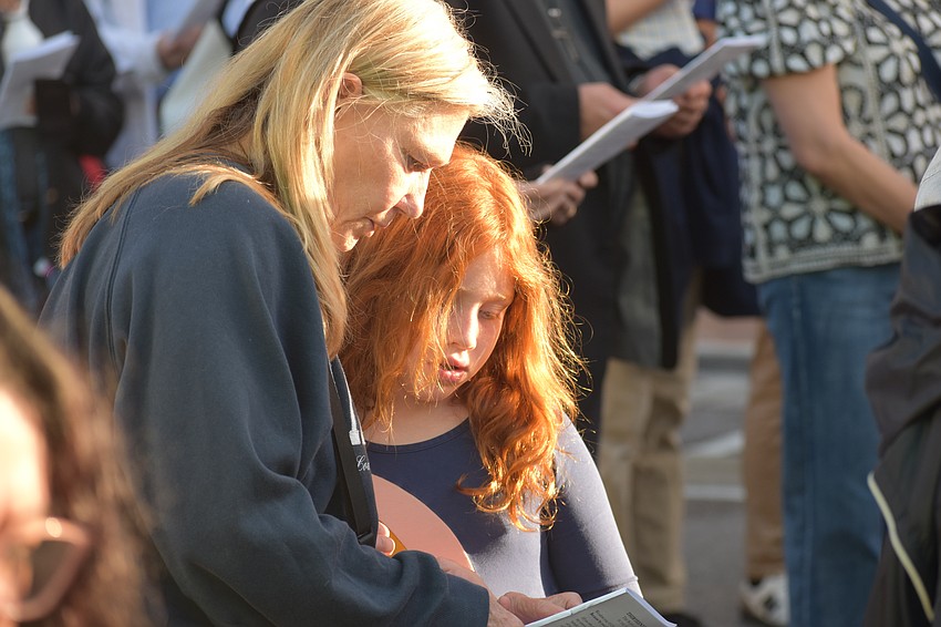 Danae Rubenzer and her granddaughter Ava Krcmar, 8, look at the program.
